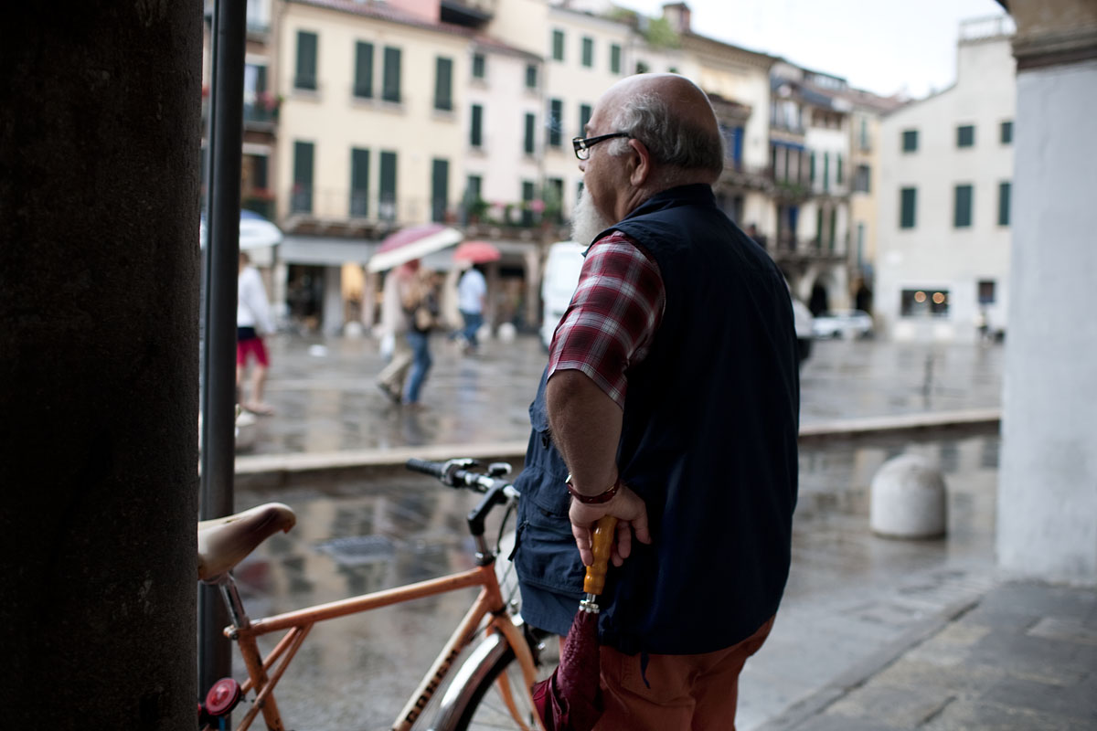 signore vecchio anziano guarda portici coperto bicicletta ombrello chiuso attesa ombrella bicycle men man canon 35mm 1.4 f/1.4 padova pioggia